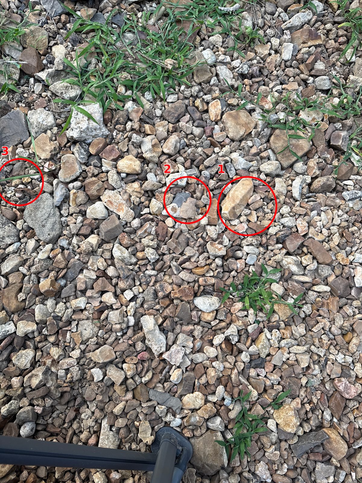 Gravel ground with green grass, three red circled spots labeled 1, 2, and 3, and a black metal leg at the bottom.